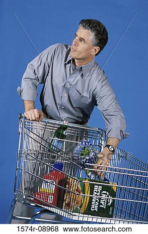 Man shopping with a shopping cart View Large Photo Image Stock Photo - Man shopping with a shopping cart. Fotosearch