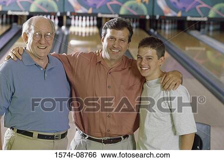 Man standing with his father and son in a bowling alley View Large Photo Image Stock Photograph - Man standing with his father and son in a bowling alley. Fotosearch