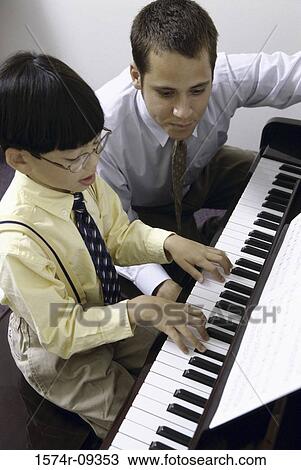 Man teaching a boy how to play the piano View Large Photo Image Stock Image - Man teaching a boy how to play the piano. Fotosearch