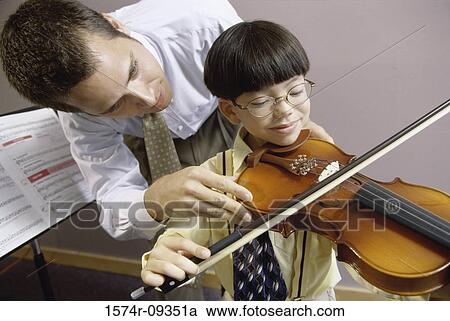 Man teaching a boy how to play the violin View Large Photo Image Stock Image - Man teaching a boy how to play the violin. Fotosearch