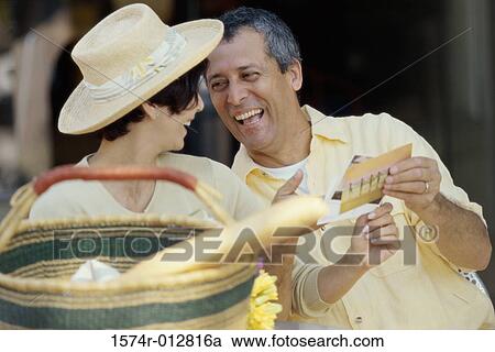 Stock Image - Mature couple choosing postcards. Fotosearch