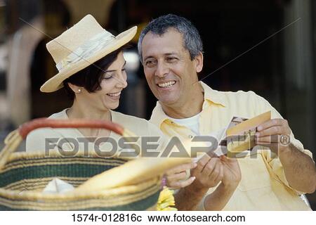 Stock Image - Mature couple choosing postcards. Fotosearch