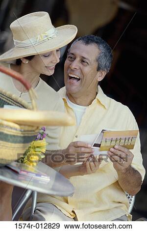 Stock Photo - Mature couple looking at postcards. Fotosearch