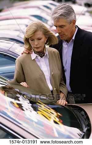 Mature couple standing near a car View Large Photo Image Stock Image - Mature couple standing near a car. Fotosearch