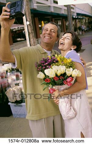 Mature couple taking a photograph of themselves View Large Photo Image Stock Image - Mature couple taking a photograph of themselves. Fotosearch