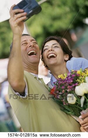 Mature couple taking a photograph of themselves View Large Photo Image Stock Image - Mature couple taking a photograph of themselves. Fotosearch