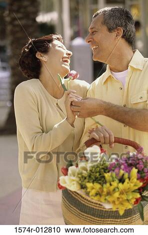 Mature man giving a flower to a mature woman View Large Photo Image Stock Image - Mature man giving a flower to a mature woman. Fotosearch