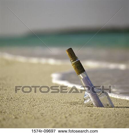 Message in bottle buried in the sand at the beach View Large Photo Image Stock Photo - Message in bottle buried in the sand at the beach. Fotosearch
