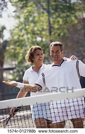 Mid adult couple playing tennis View Large Photo Image Stock Image - Mid adult couple playing tennis. Fotosearch