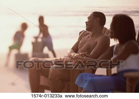 Mid adult couple sitting in chairs at the beach View Large Photo Image Stock Image - Mid adult couple sitting in chairs at the beach. Fotosearch