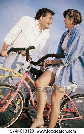 Mid adult couple standing with bicycles on the beach View Large Photo Image Stock Photo - Mid adult couple standing with bicycles on the beach. Fotosearch