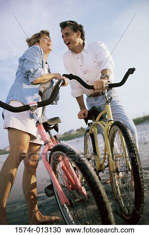 Mid adult couple standing with their bicycles on the beach View Large Photo Image Stock Image - Mid adult couple standing with their bicycles on the beach. Fotosearch