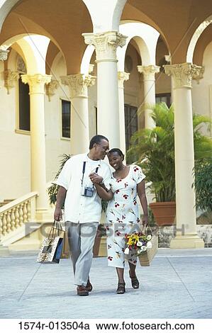 Mid adult couple walking with shopping bags View Large Photo Image Stock Image - Mid adult couple walking with shopping bags. Fotosearch