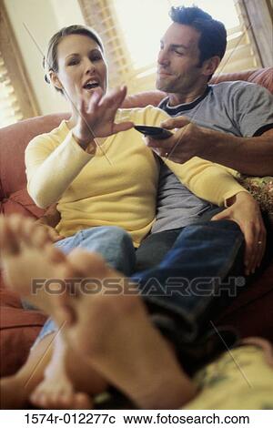 Mid adult couple watching television View Large Photo Image Stock Image - Mid adult couple watching television. Fotosearch