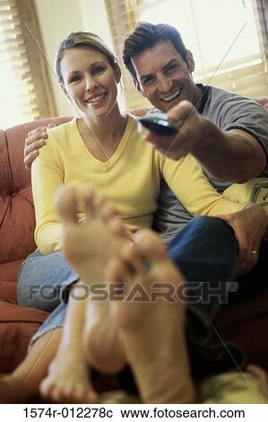 Stock Image - Mid adult couple watching television. Fotosearch