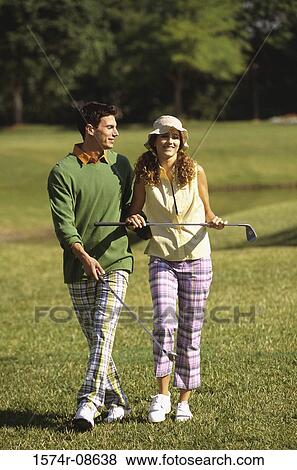 Stock Photo - Mid adult man and a mid adult woman on a golf course. Fotosearch