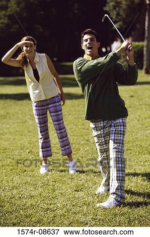 Mid adult man and a mid adult woman playing golf View Large Photo Image Stock Photo - Mid adult man and a mid adult woman playing golf. Fotosearch