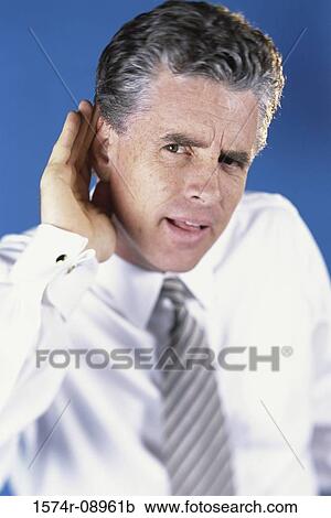 Mid adult man putting his hand behind his ear in an effort to hear better View Large Photo Image Stock Image - Mid adult man putting his hand behind his ear in an effort to hear better. Fotosearch