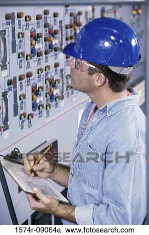 Mid adult man standing in the control room writing on a clipboard View Large Photo Image Stock Image - Mid adult man standing in the control room writing on a clipboard. Fotosearch
