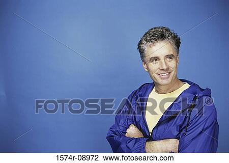 Mid adult man standing with his arms folded View Large Photo Image Stock Image - Mid adult man standing with his arms folded. Fotosearch