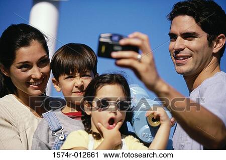 Mid adult man taking a photograph of his family View Large Photo Image Stock Image - Mid adult man taking a photograph of his family. Fotosearch