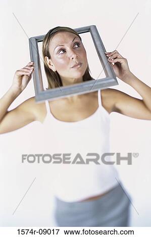 Mid adult woman holding a picture frame over her head View Large Photo Image Stock Photo - Mid adult woman holding a picture frame over her head. Fotosearch
