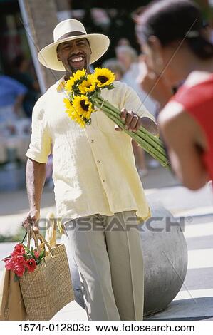 Mid adult woman taking a photograph of a mid adult man View Large Photo Image Stock Image - Mid adult woman taking a photograph of a mid adult man. Fotosearch
