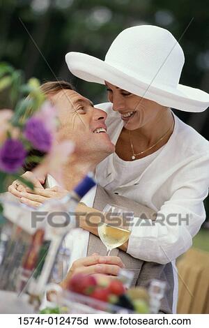 Stock Image - Mid adult woman with her arms around a mid adult man. Fotosearch