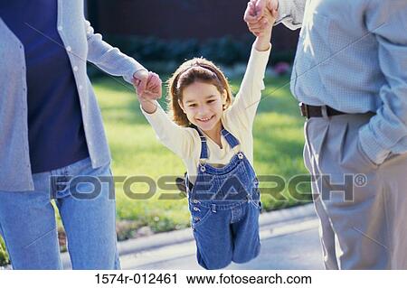 Mid section view of parents swinging their daughter View Large Photo Image Stock Image - Mid section view of parents swinging their daughter. Fotosearch