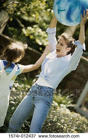 Mother and daughter playing with a ball in a garden View Large Photo Image Stock Photo - Mother and daughter playing with a ball in a garden. Fotosearch