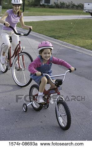 Mother and daughter riding bicycles View Large Photo Image Stock Image - Mother and daughter riding bicycles. Fotosearch