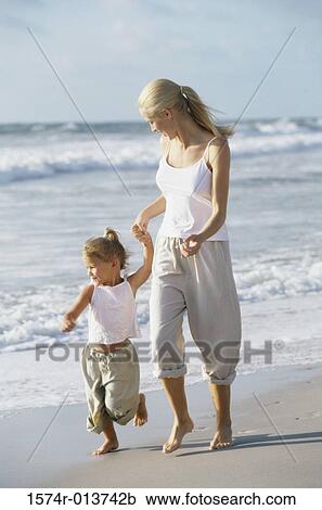 Mother and daughter walking on the beach View Large Photo Image Stock Image - Mother and daughter walking on the beach. Fotosearch