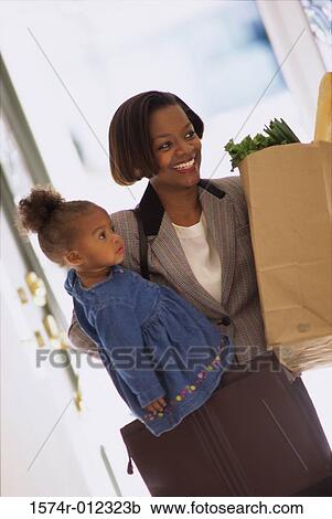 Mother carrying her daughter and holding shopping bags View Large Photo Image Stock Image - Mother carrying her daughter and holding shopping bags. Fotosearch