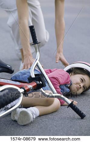 Stock Photo - Mother helping her daughter after falling from her bicycle. Fotosearch