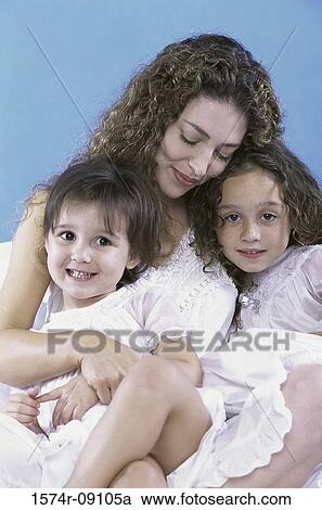 Stock Image - Mother holding her two daughters. Fotosearch