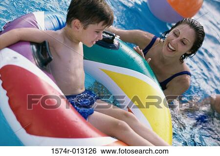 Mother in a swimming pool with her son on an inflatable ring View Large Photo Image Stock Photograph - Mother in a swimming pool with her son on an inflatable ring. Fotosearch