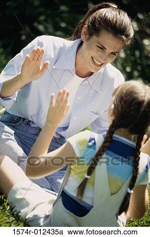 Mother playing with her daughter in a park View Large Photo Image Stock Image - Mother playing with her daughter in a park. Fotosearch