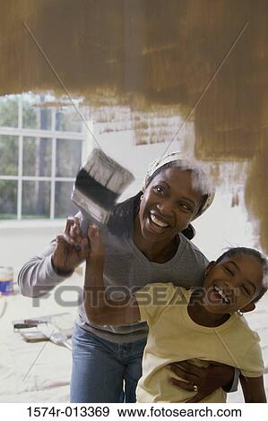 Mother teaching her daughter to paint View Large Photo Image Stock Photo - Mother teaching her daughter to paint. Fotosearch