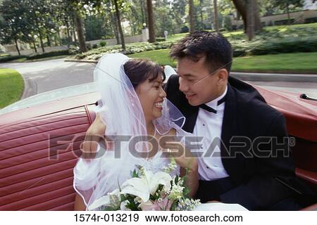 Newlywed couple sitting in a convertible car View Large Photo Image Stock Photo - Newlywed couple sitting in a convertible car. Fotosearch