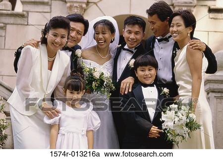 Newlywed couple standing with their parents and wedding guests View Large Photo Image Stock Image - Newlywed couple standing with their parents and wedding guests. Fotosearch