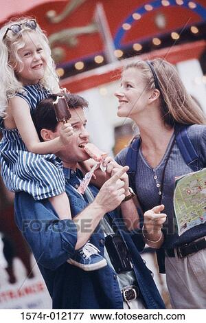 Parents and their daughter in an amusement park View Large Photo Image Stock Photo - Parents and their daughter in an amusement park. Fotosearch
