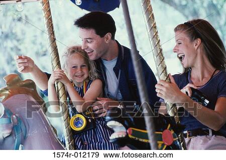 Parents and their daughter sitting on carousel horses View Large Photo Image Stock Photo - Parents and their daughter sitting on carousel horses. Fotosearch