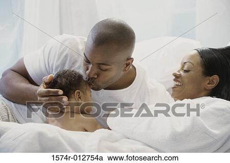 Parents and their son on the bed View Large Photo Image Stock Image - Parents and their son on the bed. Fotosearch