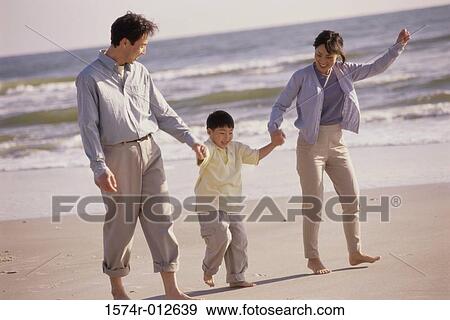 Parents and their son walking on the beach View Large Photo Image Stock Photo - Parents and their son walking on the beach. Fotosearch