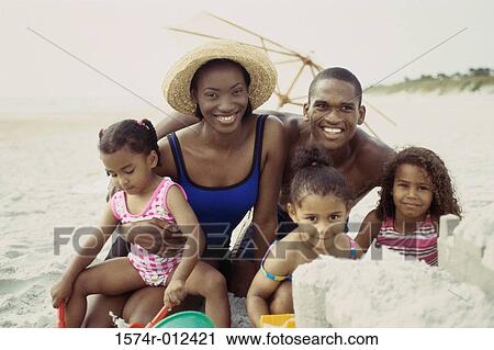 Parents and their three daughters sitting on the beach View Large Photo Image Stock Image - Parents and their three daughters sitting on the beach. Fotosearch