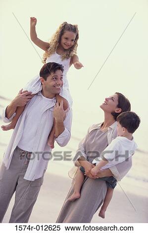 Stock Photography - Parents and their two children on the beach. Fotosearch