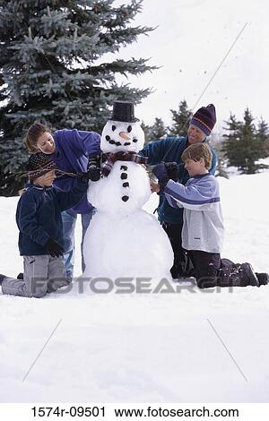 Parents and their two sons building a snowman View Large Photo Image Stock Image - Parents and their two sons building a snowman. Fotosearch