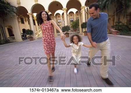 Parents holding hands with their daughter and running View Large Photo Image Stock Image - Parents holding hands with their daughter and running. Fotosearch