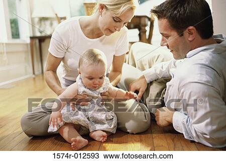 Stock Image - Parents looking at their daughter smiling. Fotosearch