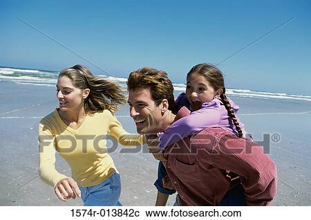Parents playing with their daughter on the beach View Large Photo Image Stock Image - Parents playing with their daughter on the beach. Fotosearch
